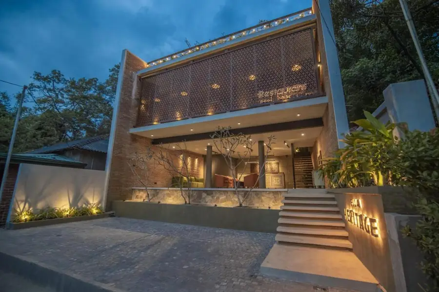 Front of Ella Heritage at sunset, with the entrance stairs and the sign, in Ella, Sri Lanka